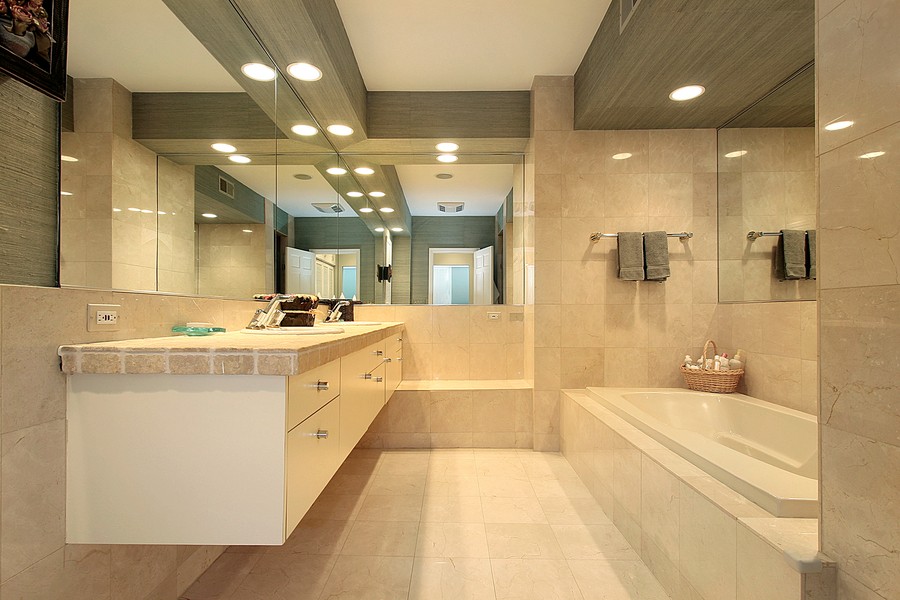  Image is of a modern bathroom with overhead lighting design.